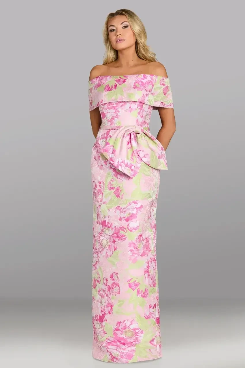 A model wearing a floral off-the-shoulder gown with a bow detail at the waist.