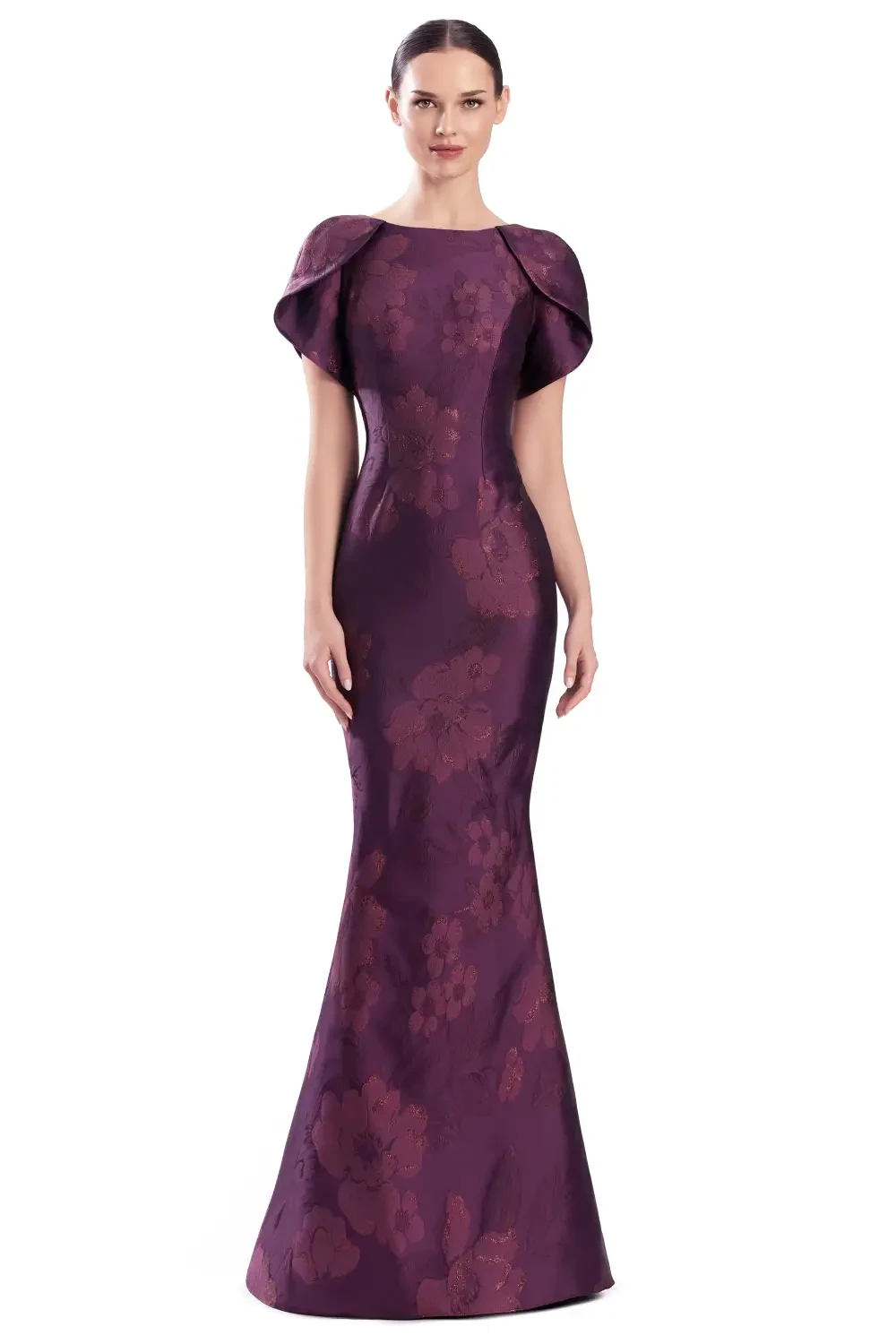 A woman in a fitted purple gown with floral designs and a cape-like neckline.