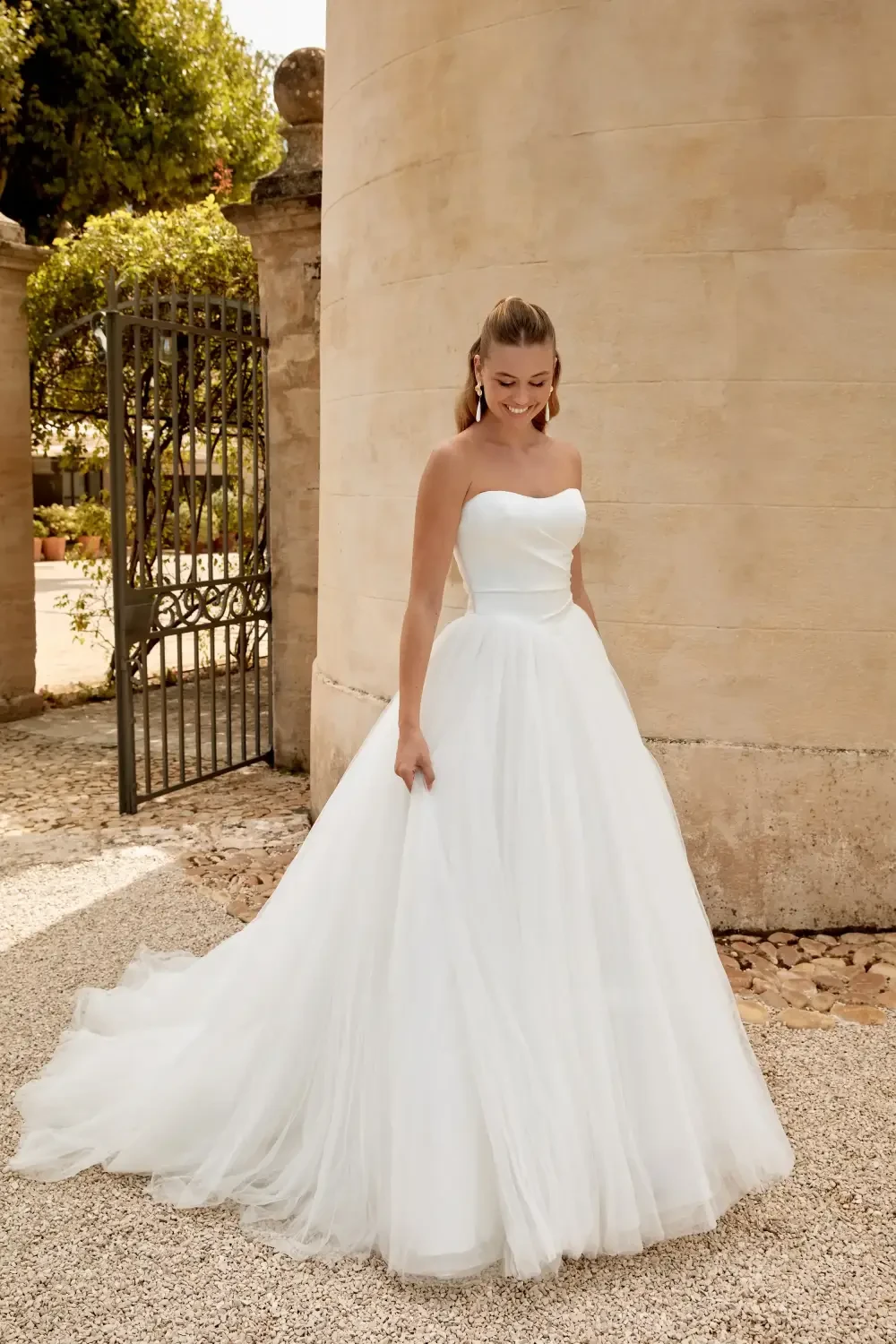 model is wearing an open back ball gown