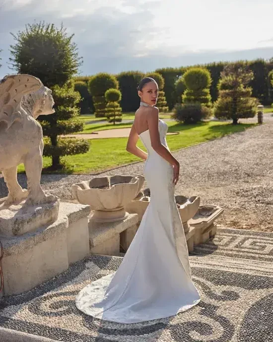 model is wearing a strapless brocade fit and flare wedding gown