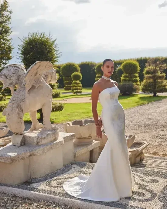 model is wearing a strapless brocade fit and flare wedding gown