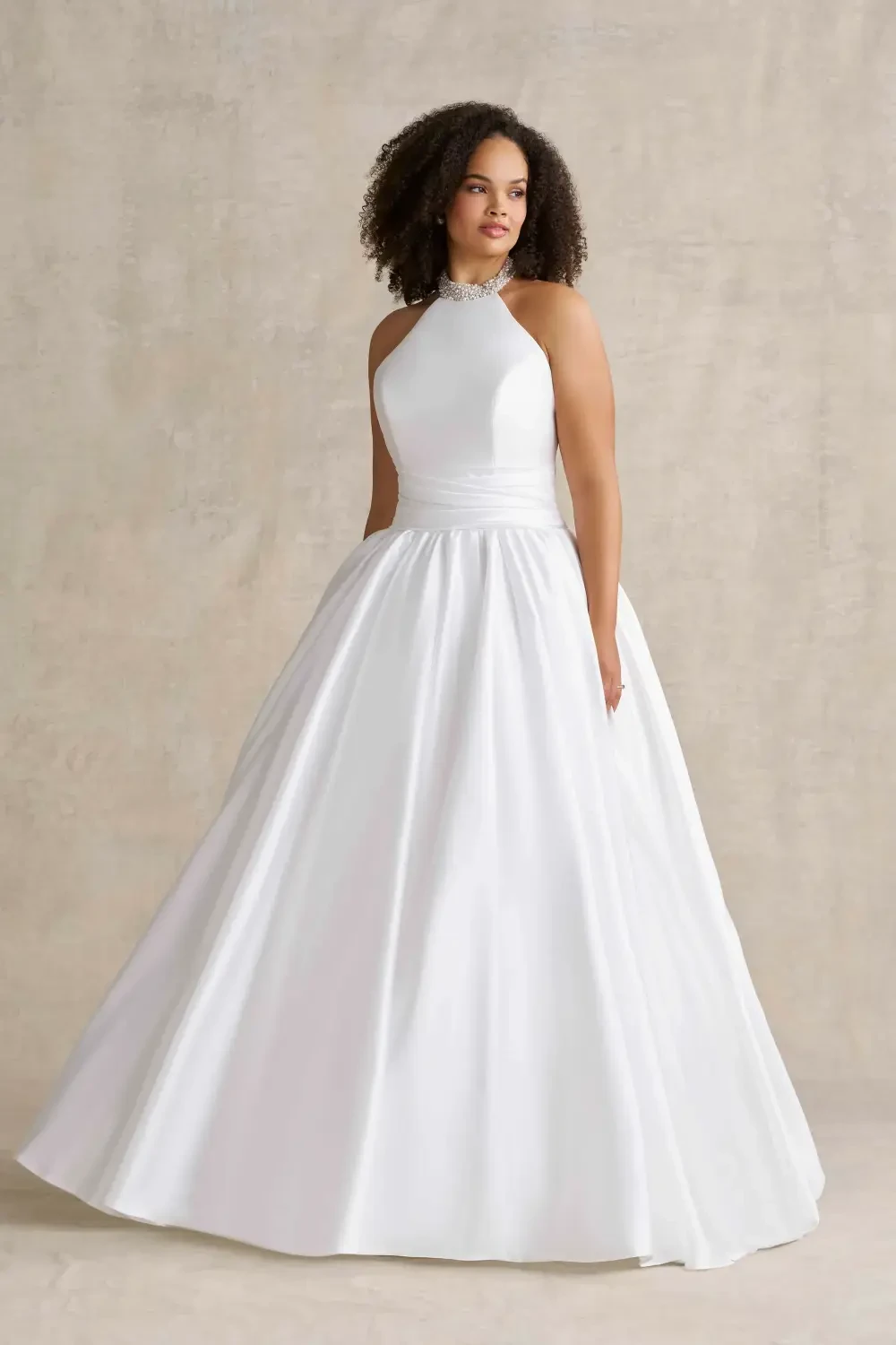 model is wearing a sleeveless high neck bridal gown
