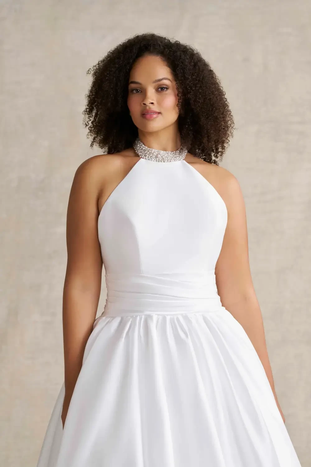 model is wearing a sleeveless high neck bridal gown