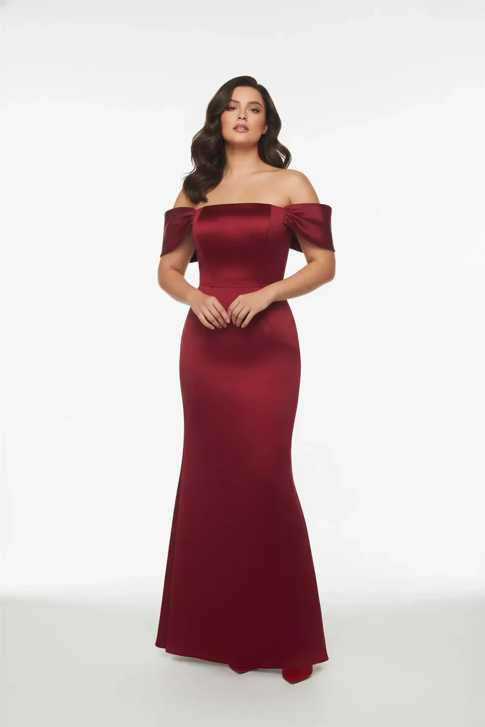 A model wearing a burgundy off-the-shoulder gown.