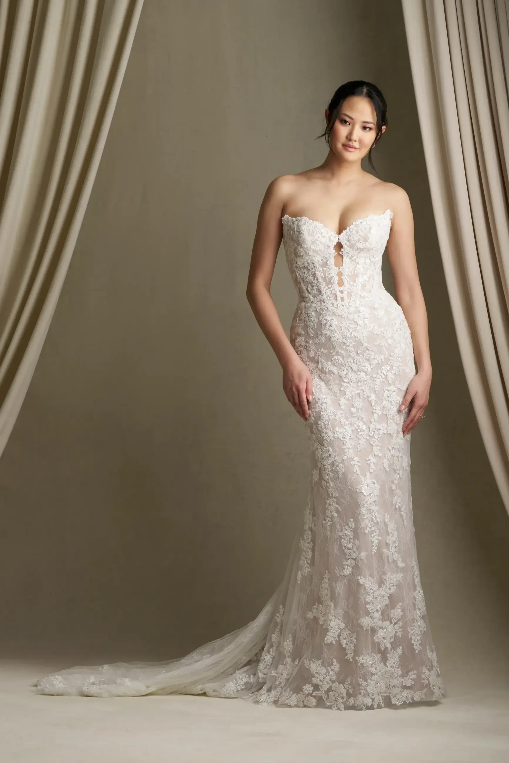model is wearing a strapless lace bridal gown