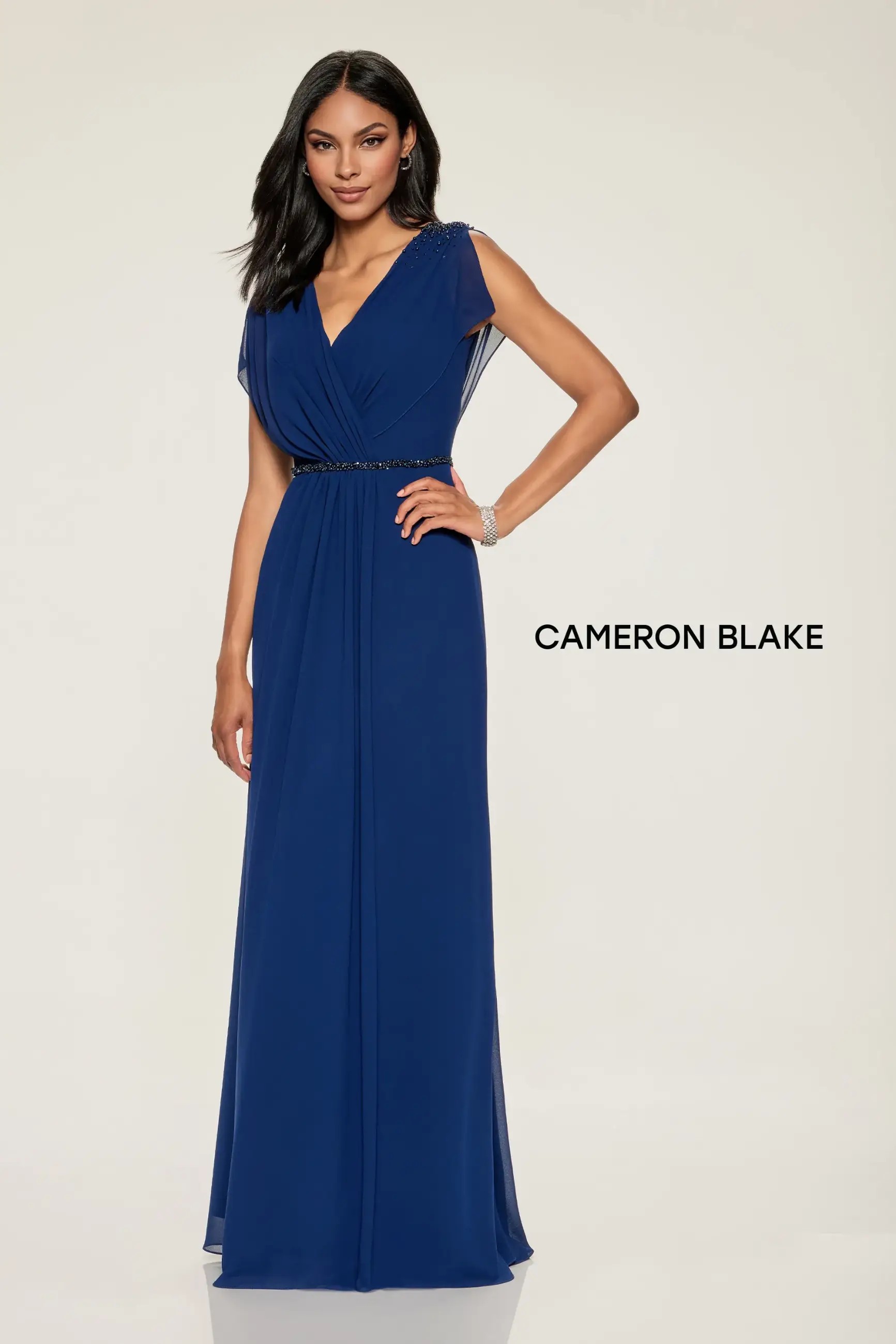 Model is wearing an a-line evening gown with a v-neckline and sparkling beaded belt by cameron blake