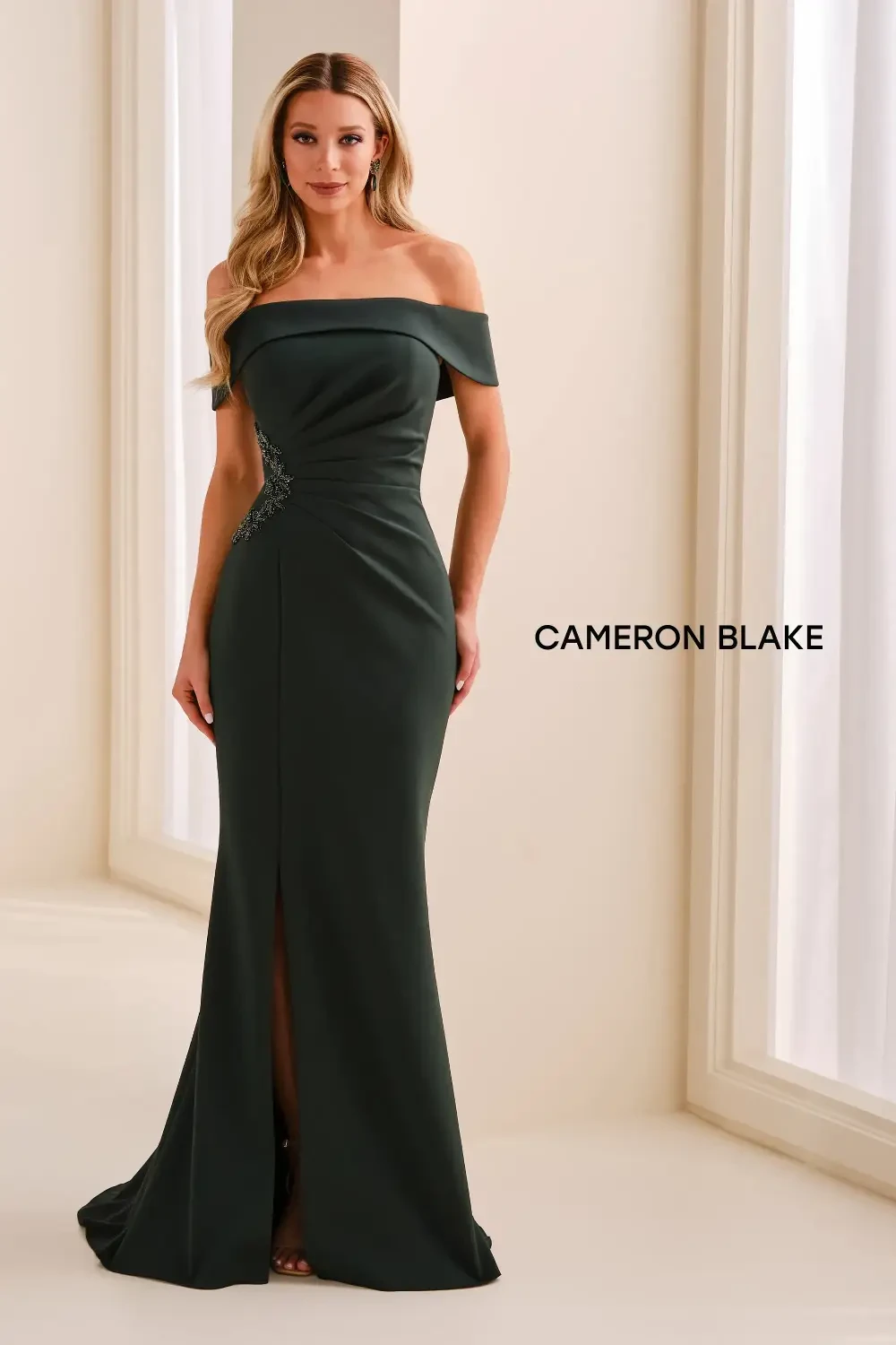 model is wearing an off the shoulder mother of the bride gown