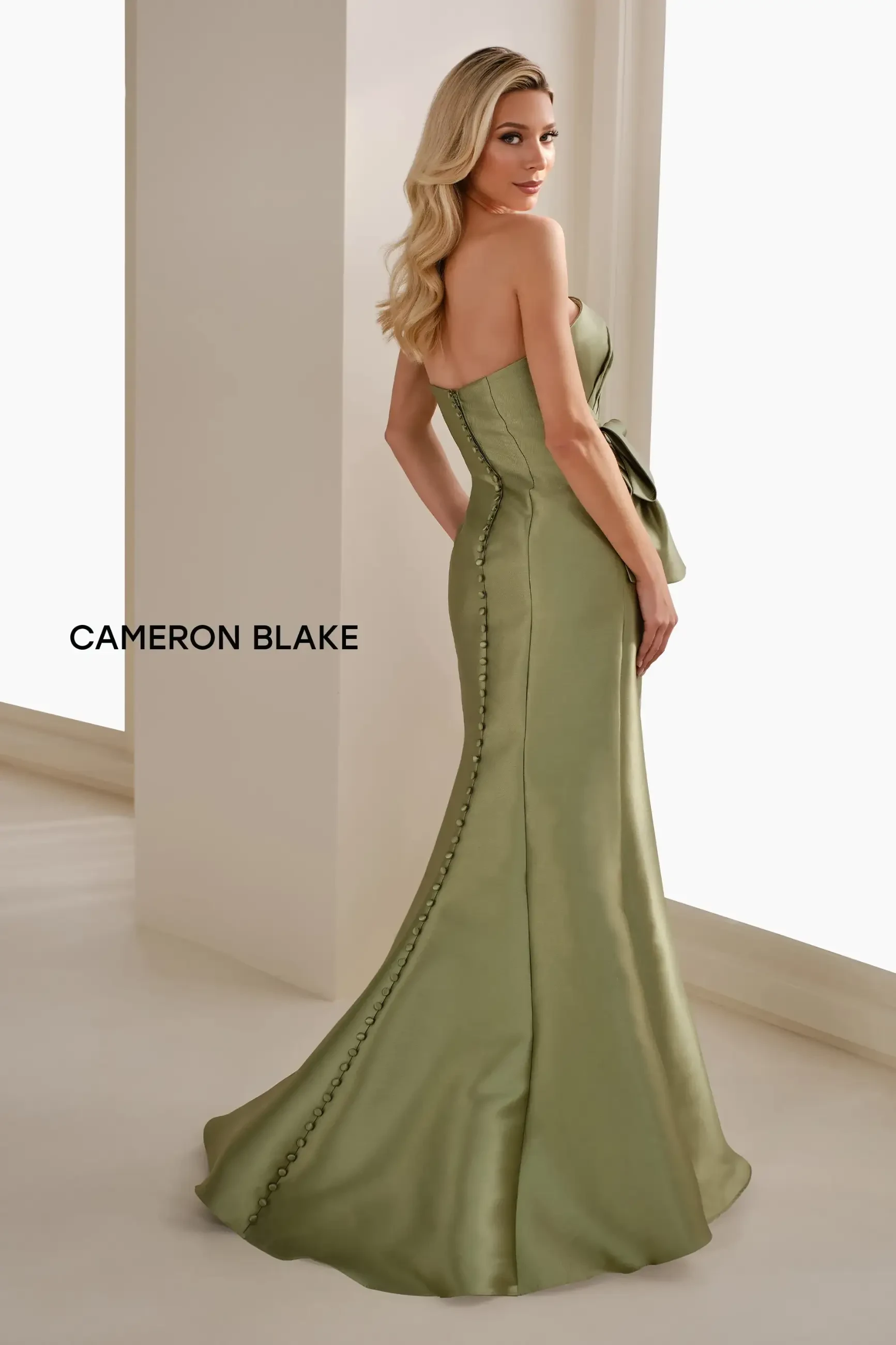 Model is wearing the Cameron Blake CB909, an apple green strapless Mikado mermaid gown with separate spaghetti straps and a matching Mikado shawl for versatile elegance.