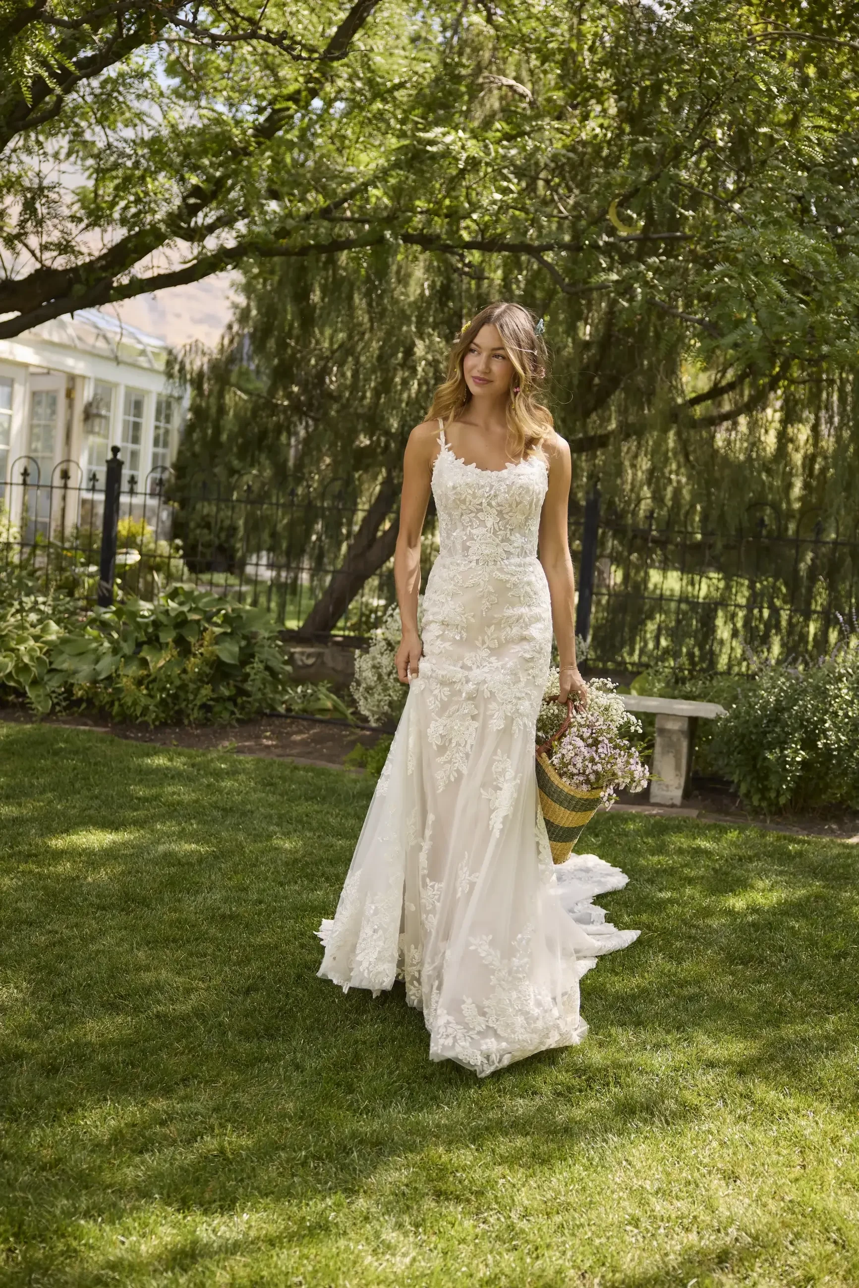model is wearing a sleeveless sheath bridal gown