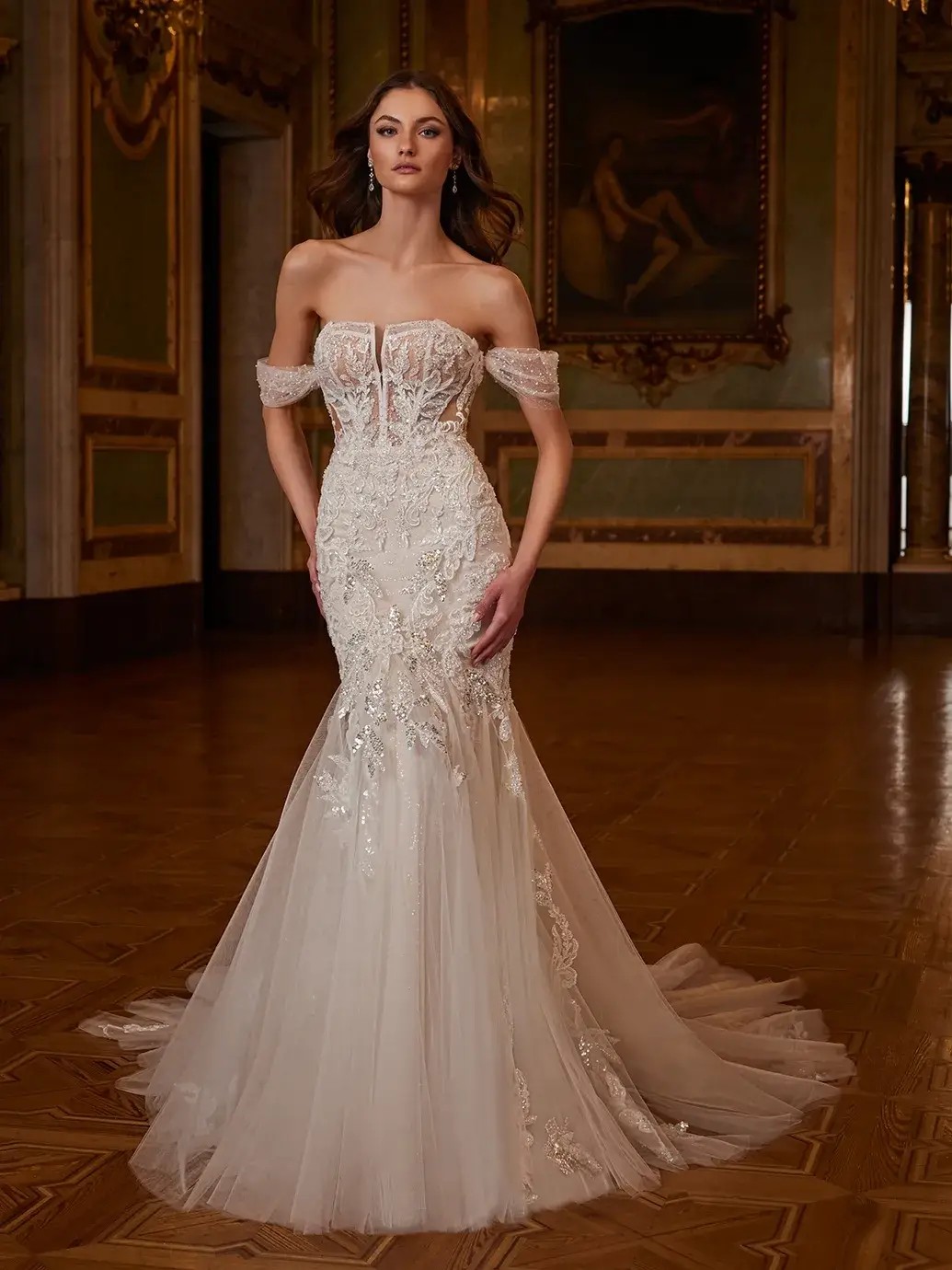 Model is wearing a wedding dress with a detachable ball gown overskirt and romantic floral embroidery