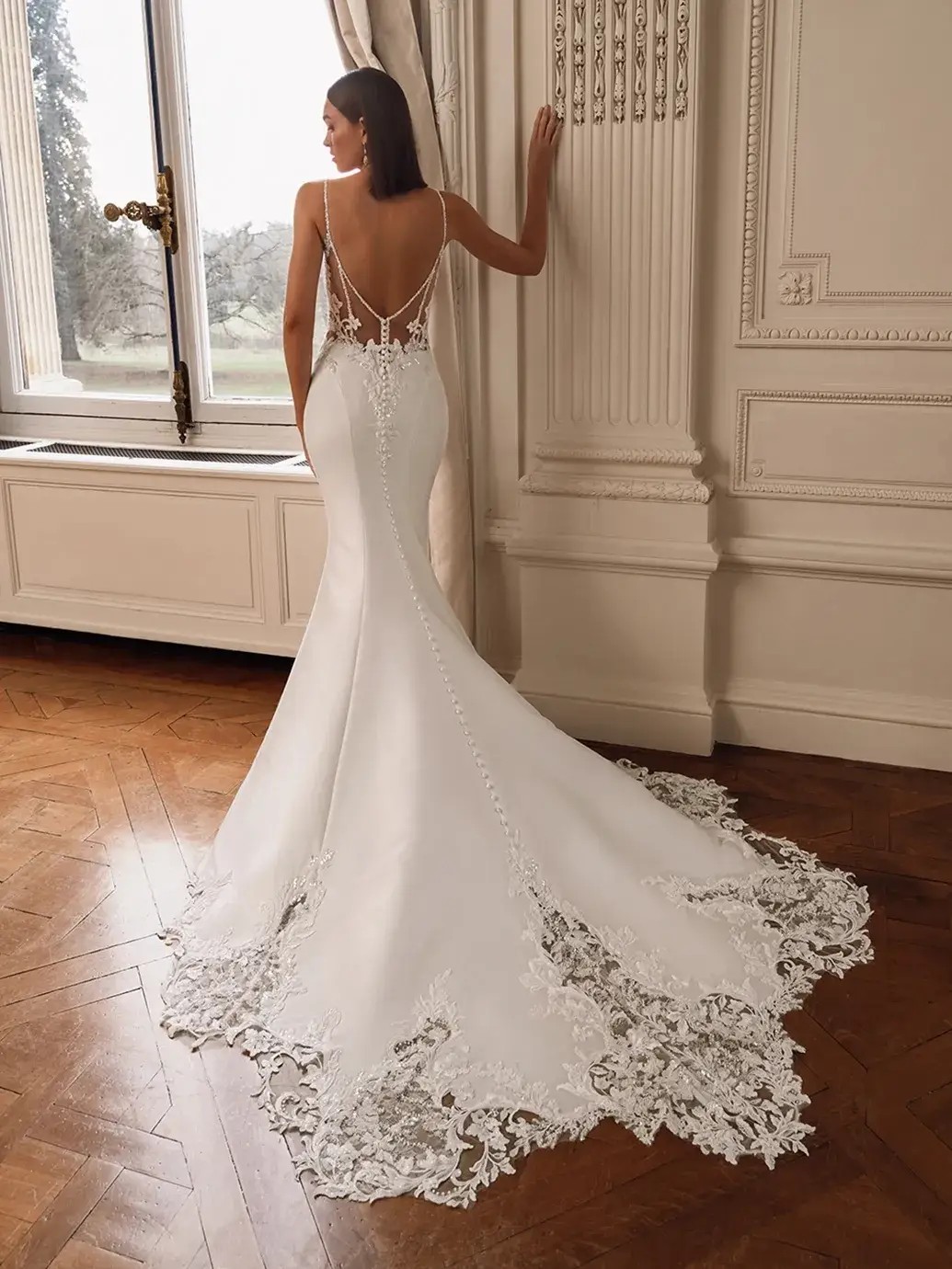 Model is wearing a mikado mermaid wedding dress with a slit and deep v neckline