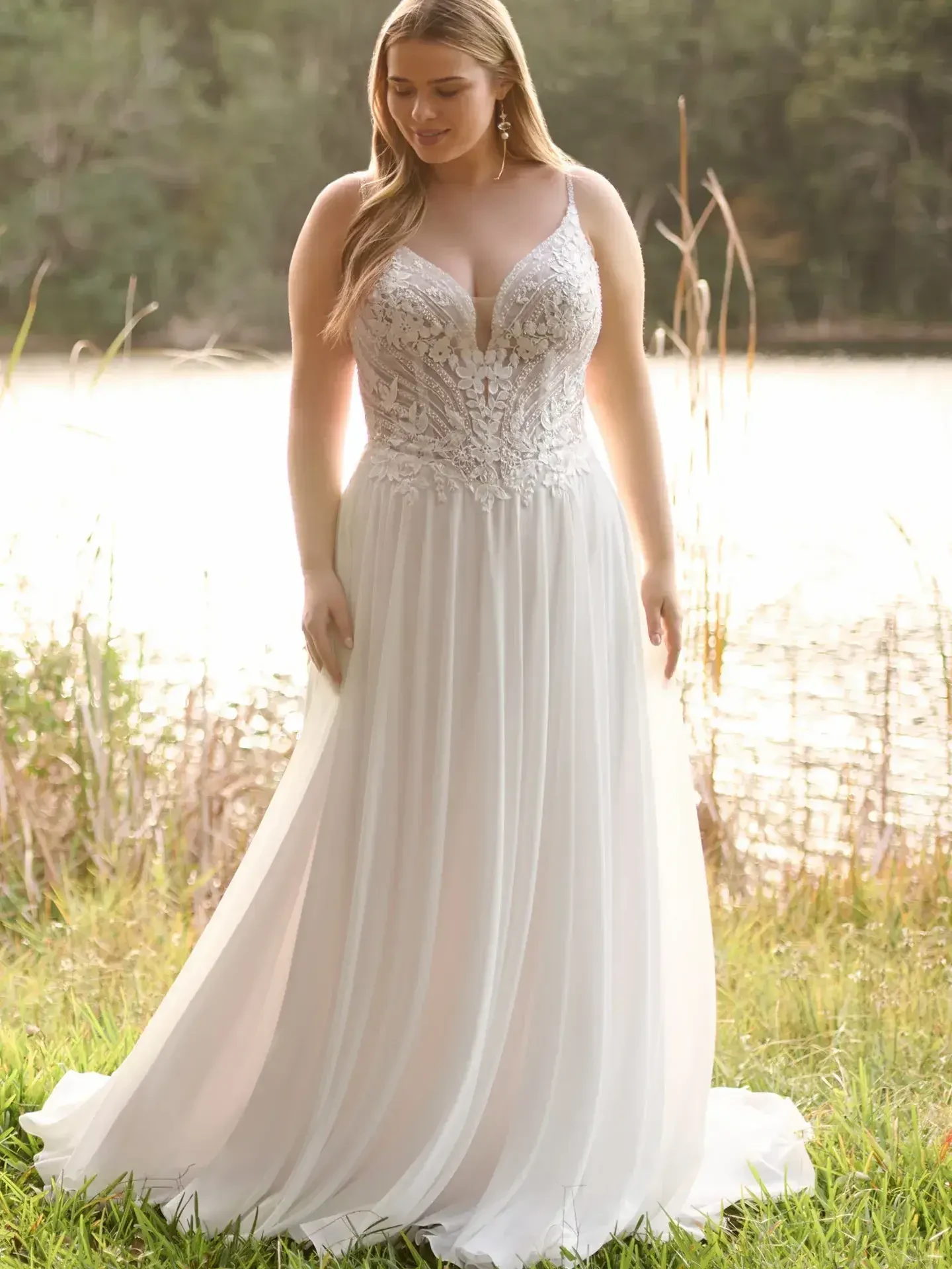 Model is wearing a flowing A-line gown with a plunging neckline, offering understated elegance and graceful movement.