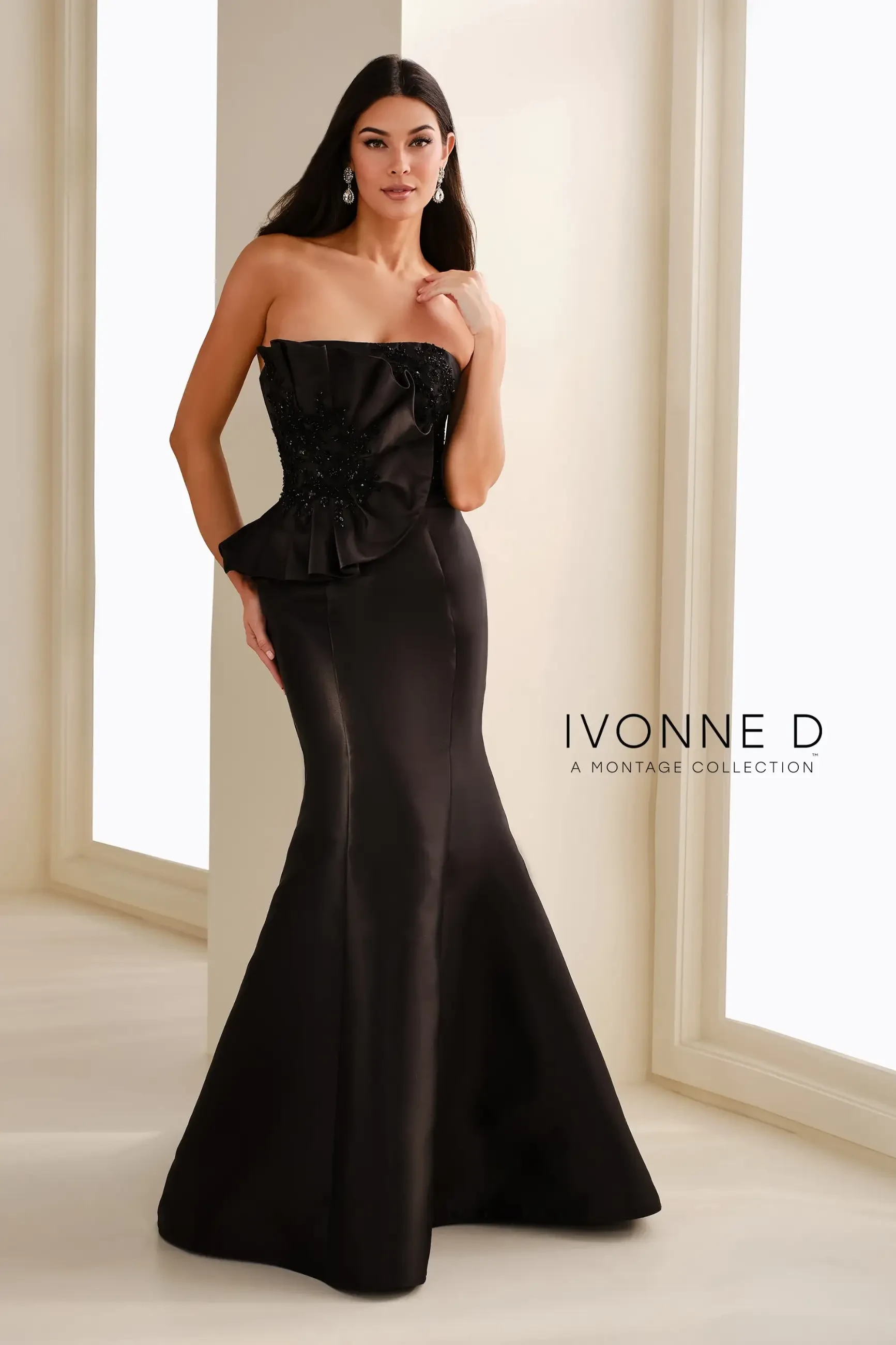model is wearing a black strapless mermaid evening gown
