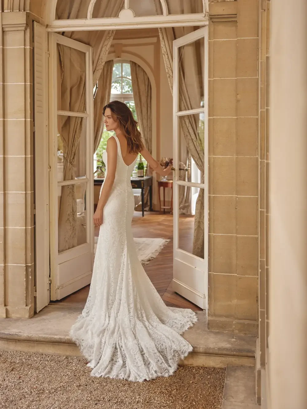 model is wearing an open back bridal gown
