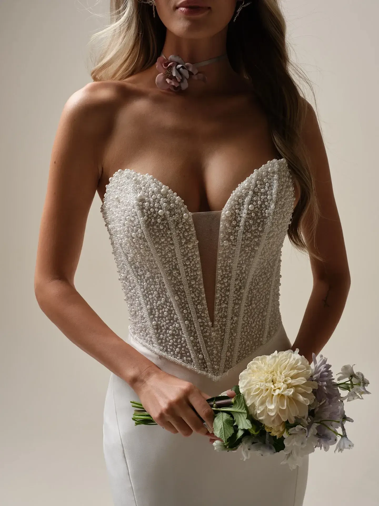 model is wearing a strapless a-line wedding gown with pearls encrusted on the bodice
