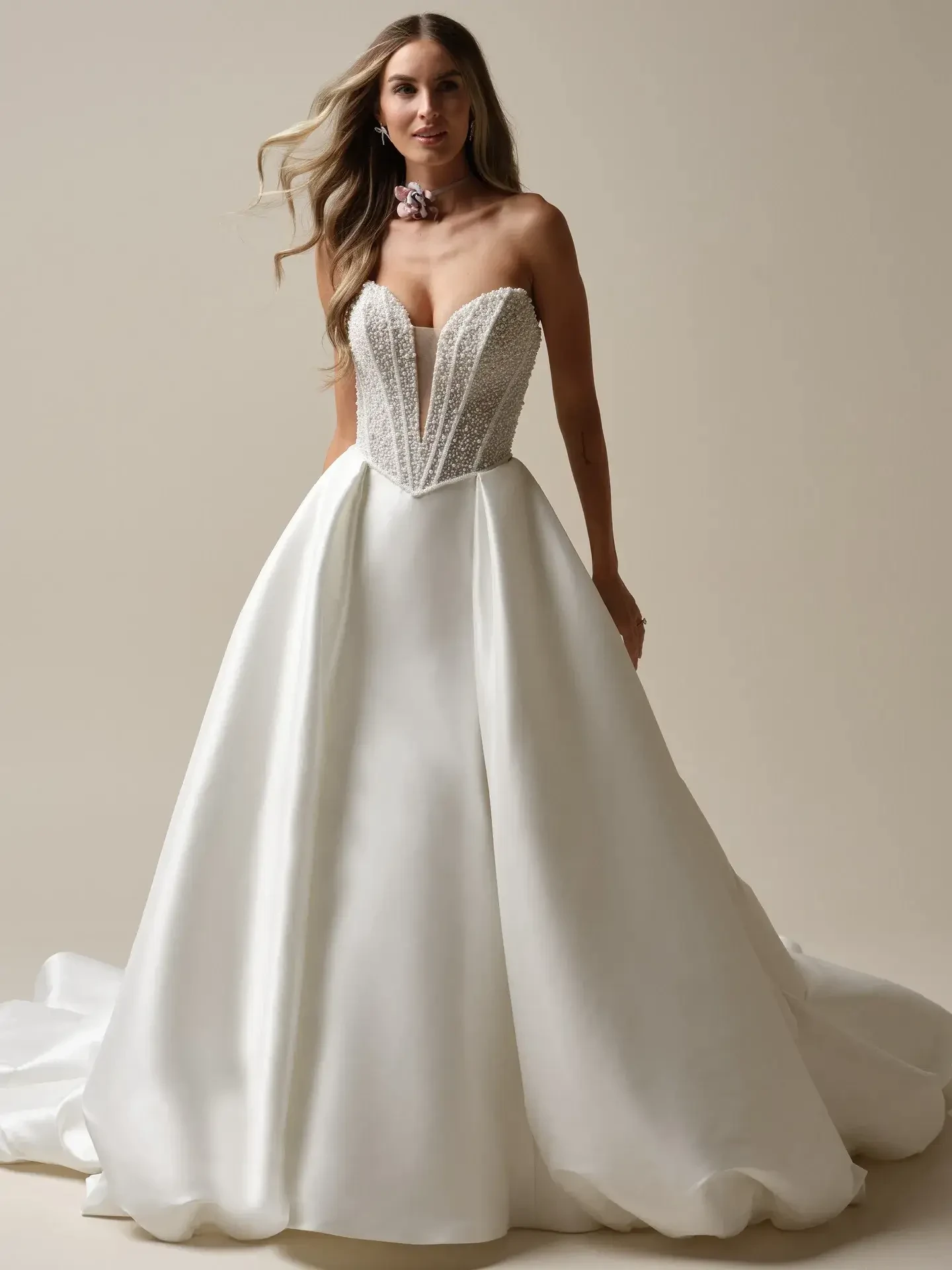 model is wearing a strapless a-line wedding gown with pearls encrusted on the bodice