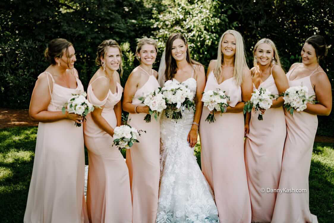 Photo of real bride girls holding bouquets and wearing rose gowns
